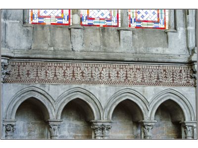 Frise à incrustations au-dessus du triforium (XIIIe s.) : feuillages habités de têtes humaines et animales,